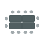 A rectangular arrangement of tables with chairs around the outside. 