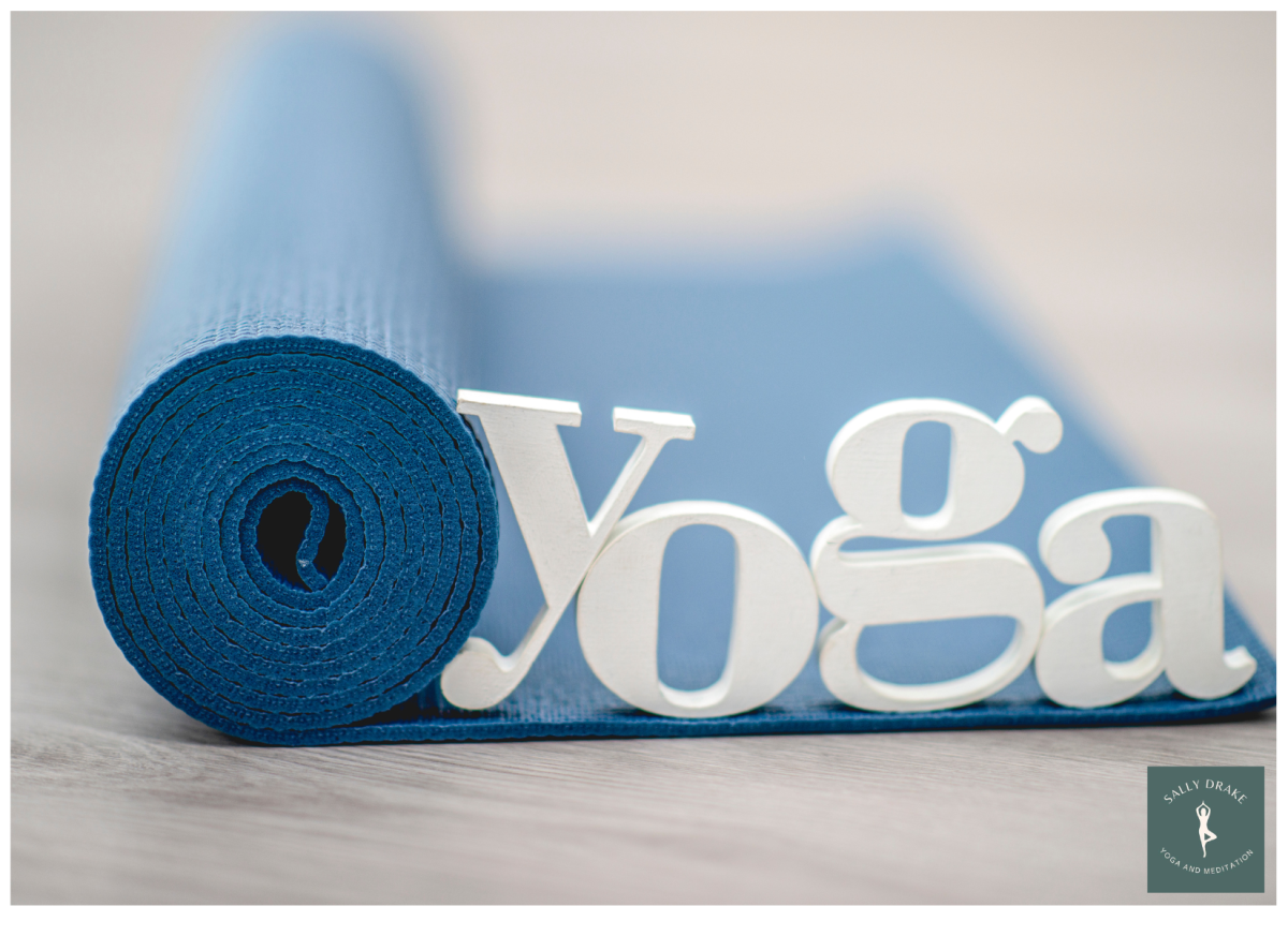 blue yoga mat with white letters spelling yoga